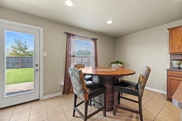 tiled dining room featuring a textured ceiling and a wealth of natural light