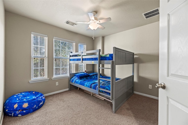 bedroom featuring carpet flooring, a textured ceiling, and ceiling fan