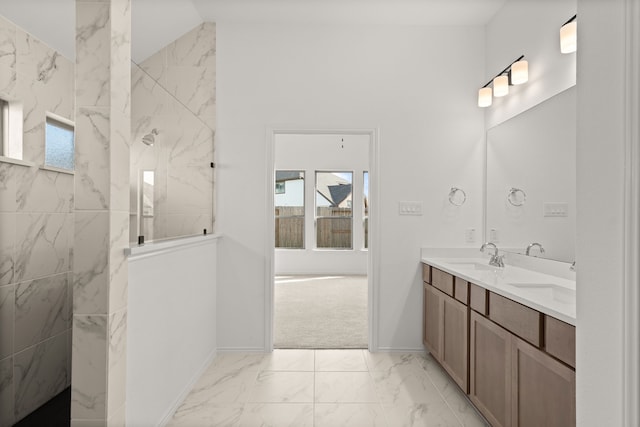 bathroom featuring a tile shower, vanity, and a healthy amount of sunlight