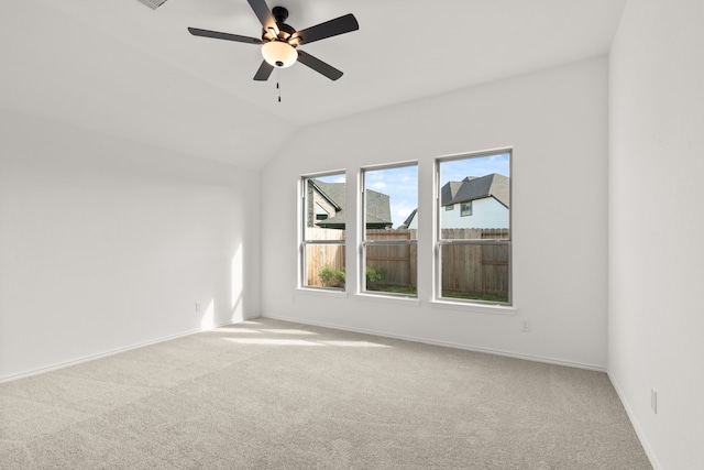 carpeted empty room with ceiling fan and lofted ceiling