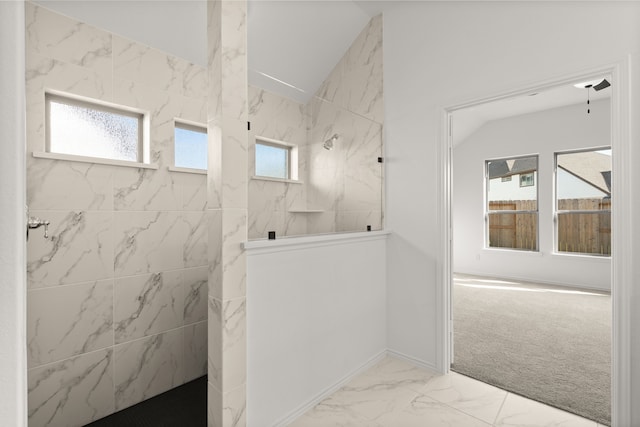 bathroom featuring a tile shower and a wealth of natural light