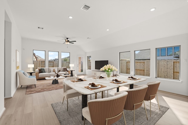 dining room featuring ceiling fan, light hardwood / wood-style flooring, and vaulted ceiling