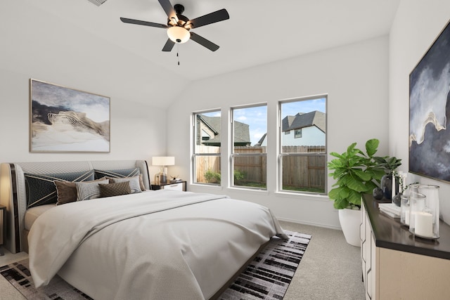 bedroom with ceiling fan, light colored carpet, and lofted ceiling