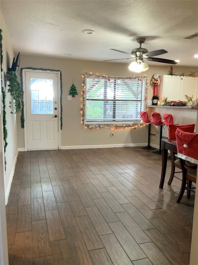 unfurnished dining area with hardwood / wood-style flooring, plenty of natural light, and ceiling fan