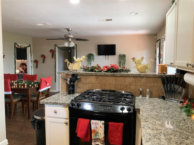 kitchen with gas stove, white cabinetry, and backsplash