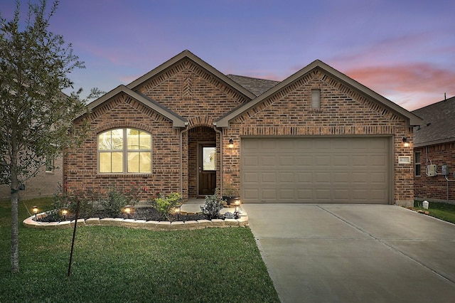 view of front of house featuring a garage and a yard