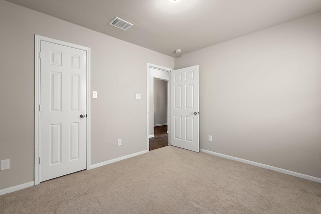 unfurnished bedroom featuring light carpet