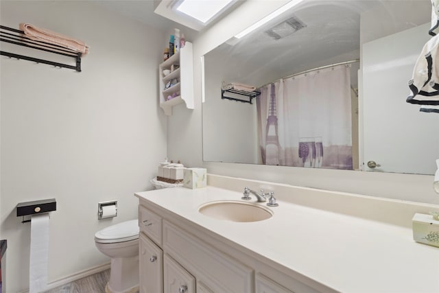 bathroom with a shower with curtain, vanity, and toilet