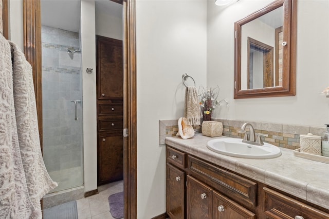 bathroom featuring decorative backsplash, vanity, tile patterned floors, and an enclosed shower