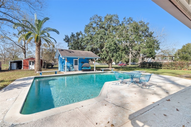 view of swimming pool with a diving board, a patio area, an outdoor structure, and a yard