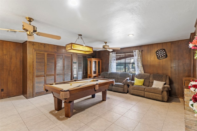 recreation room with ceiling fan, wooden walls, light tile patterned floors, and pool table