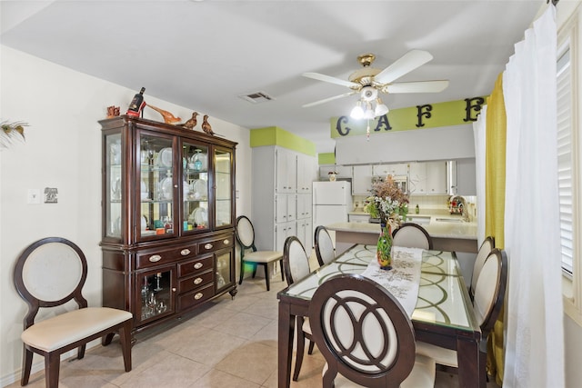 tiled dining area featuring ceiling fan and sink