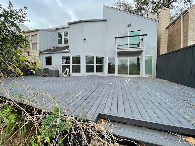 rear view of property featuring a deck and central AC unit