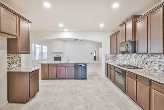 kitchen with ceiling fan, sink, black appliances, and light stone counters