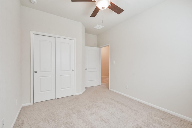 unfurnished bedroom featuring ceiling fan, a closet, and light carpet