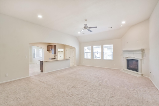 unfurnished living room with ceiling fan, light carpet, and lofted ceiling