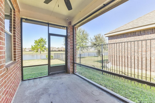 unfurnished sunroom with a wealth of natural light, a water view, and ceiling fan