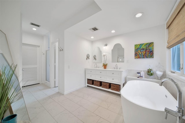 bathroom featuring a tub to relax in and vanity