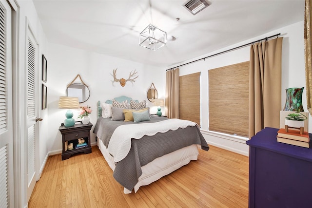 bedroom featuring wood-type flooring and an inviting chandelier