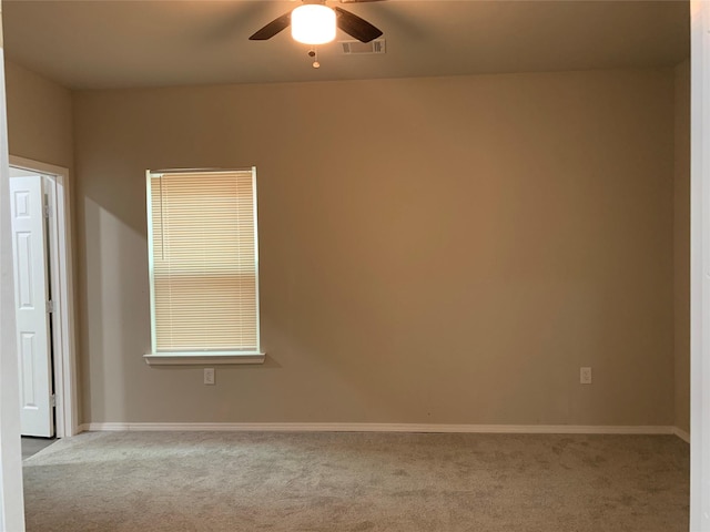 carpeted spare room with ceiling fan