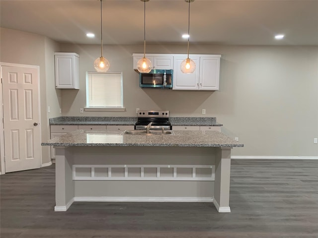 kitchen with light stone counters, pendant lighting, white cabinets, and stainless steel appliances