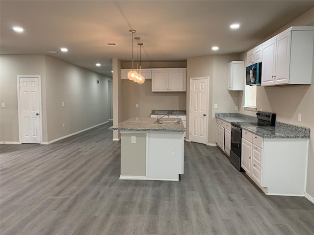 kitchen with black appliances, decorative light fixtures, a center island with sink, and white cabinets