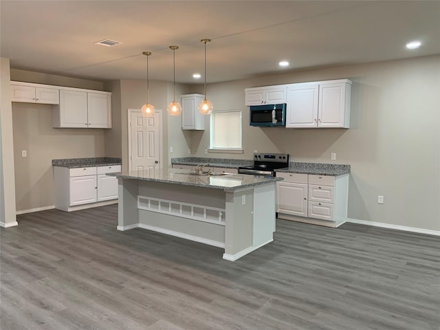 kitchen with stainless steel electric range oven, a center island with sink, white cabinets, and light stone countertops