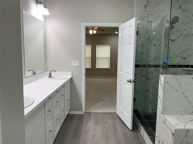 bathroom featuring vanity, ceiling fan, an enclosed shower, and wood-type flooring