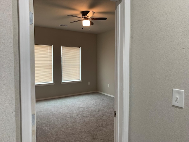 carpeted spare room with ceiling fan