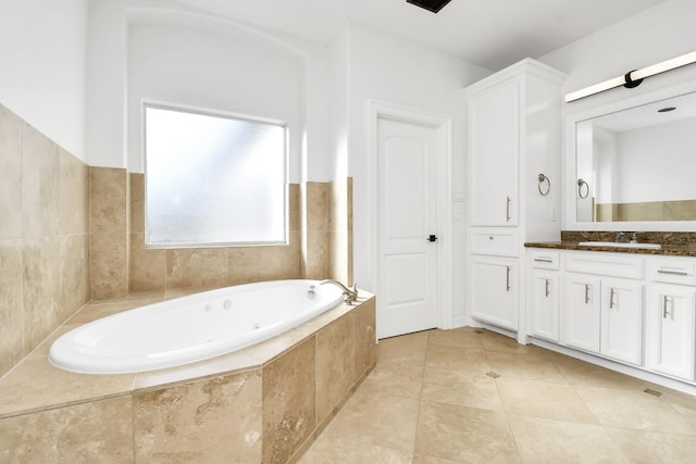 bathroom featuring tile patterned flooring, vanity, and a relaxing tiled tub