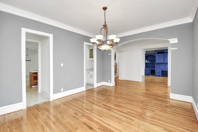 unfurnished dining area with light hardwood / wood-style floors, crown molding, and a chandelier