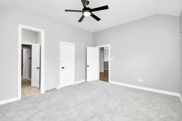 unfurnished bedroom featuring ceiling fan, light colored carpet, and lofted ceiling