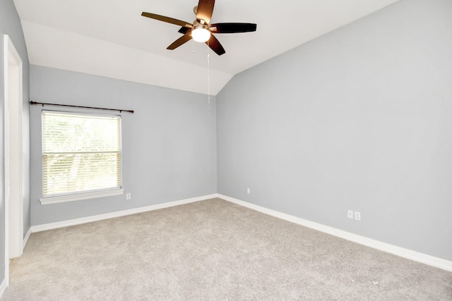 empty room featuring ceiling fan, light colored carpet, and vaulted ceiling