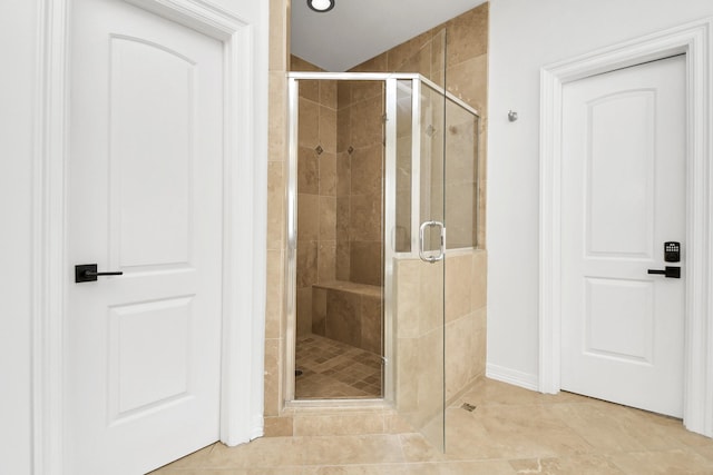 bathroom with tile patterned flooring and a shower with door