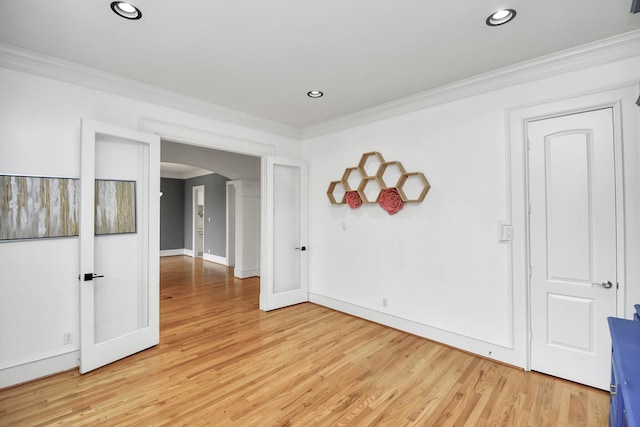 empty room featuring light wood-type flooring and ornamental molding