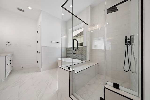 bathroom featuring vanity and separate shower and tub