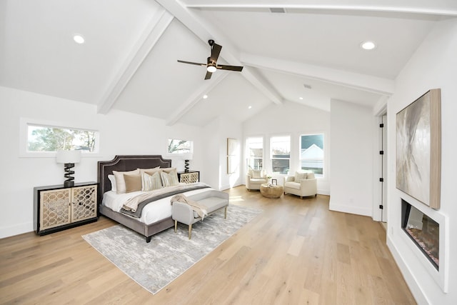 bedroom featuring multiple windows, beam ceiling, light wood-type flooring, and ceiling fan