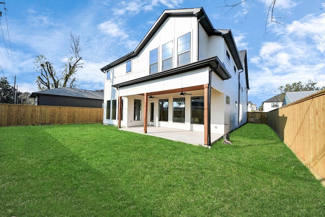 rear view of house with a patio, ceiling fan, and a lawn