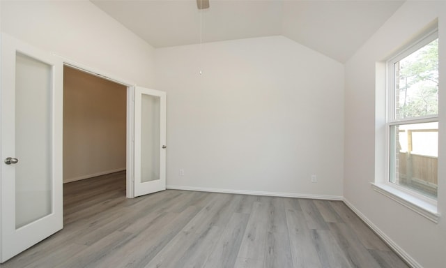 interior space featuring plenty of natural light, vaulted ceiling, light wood-type flooring, and french doors