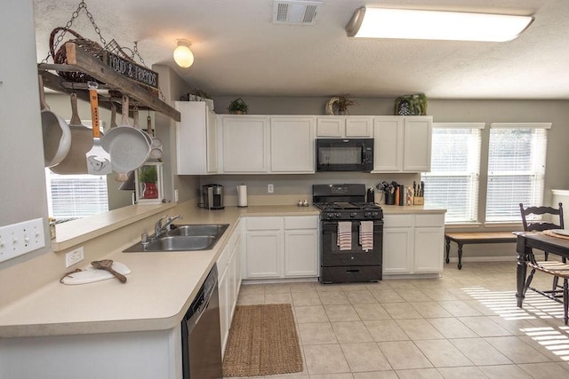 kitchen featuring black appliances, sink, light tile patterned floors, white cabinetry, and kitchen peninsula