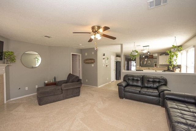 living room with ceiling fan, a fireplace, and light carpet