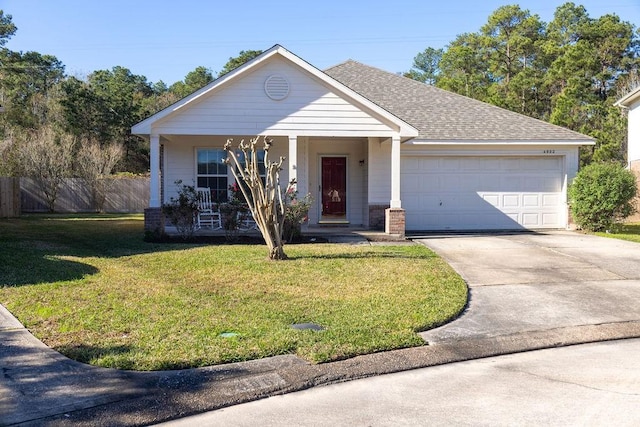 view of front of house featuring a front yard, a garage, and covered porch