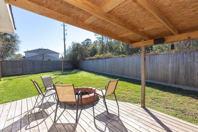 deck featuring an outdoor fire pit and a lawn