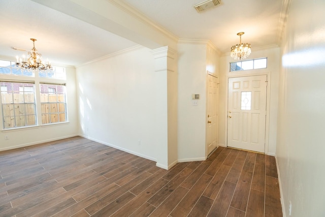 entrance foyer featuring dark hardwood / wood-style floors, an inviting chandelier, and crown molding