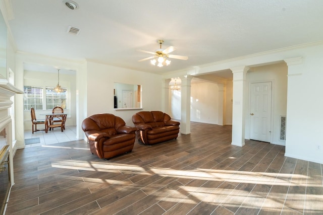 living room with ceiling fan, crown molding, and decorative columns