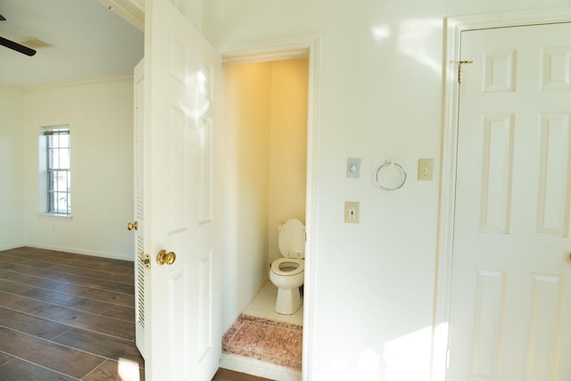 bathroom with toilet, wood-type flooring, and ornamental molding