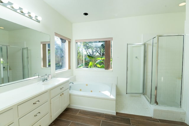 bathroom featuring vanity and independent shower and bath