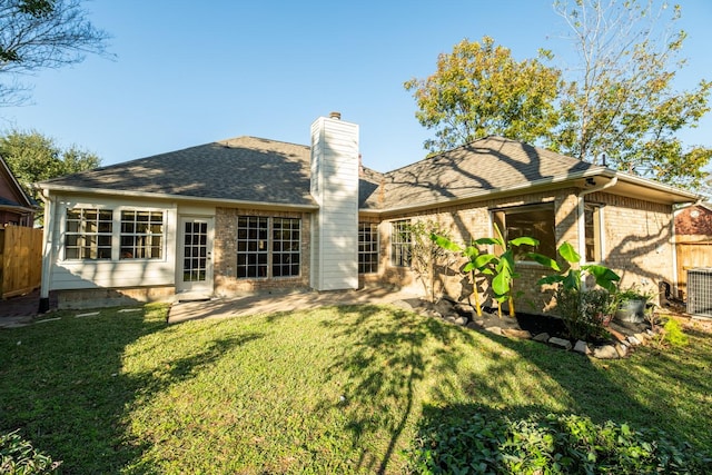 rear view of property with a lawn