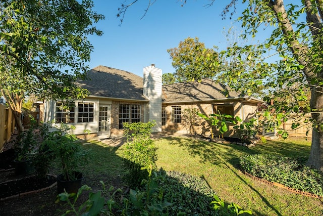 rear view of property featuring a lawn