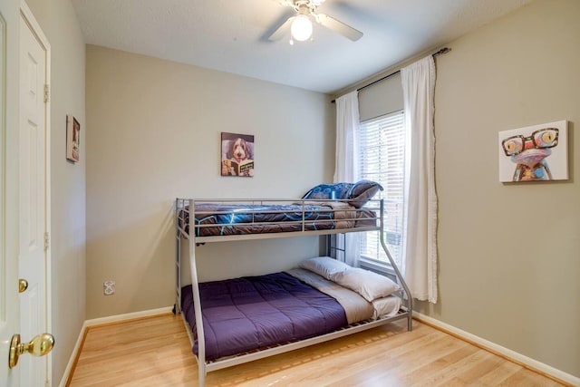 bedroom with hardwood / wood-style flooring, ceiling fan, and multiple windows